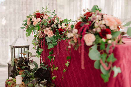 红布上的红色和粉红色花朵的婚礼餐桌装饰图片