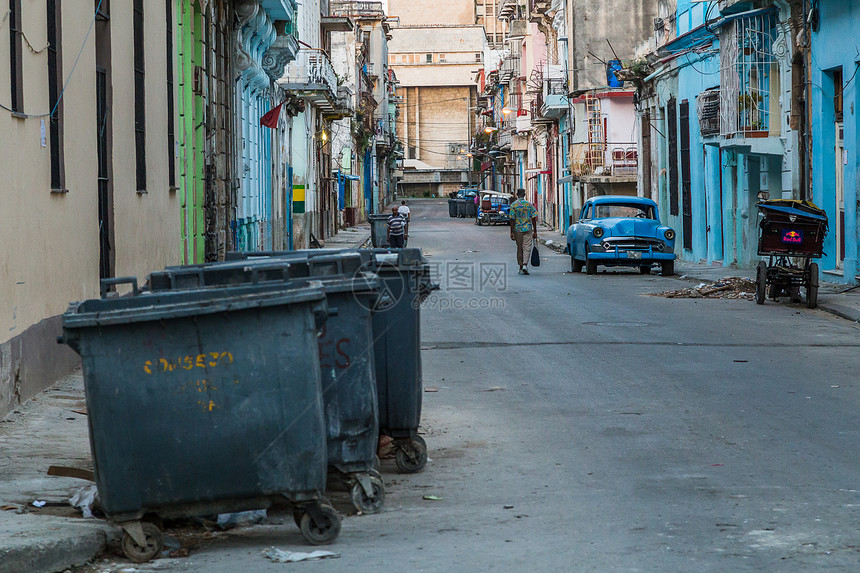 一天早上日出后不久拍摄的哈瓦那市中心典型的后街这包括停在路边的经典汽车三轮出租车路上的碎片和垃圾避难集装箱图片