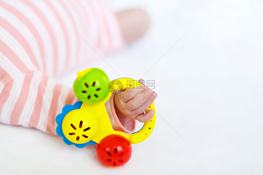 可爱的新生婴儿在白色背景上玩很多五颜六色的拨浪鼓玩具新出生的孩子小女孩和手拿着玩具的特写镜头家庭图片
