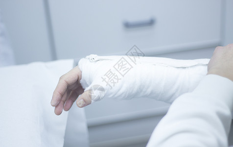 医生对病人前臂和手腕施用石膏和绷带图片