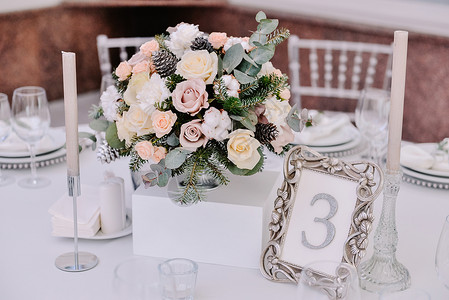 用蜡烛和花束装饰的婚桌白色和银色图片