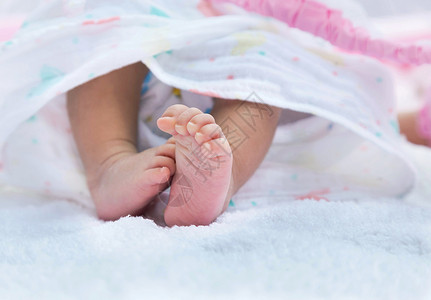 紧的婴儿小脚新生儿被白毛巾覆盖图片