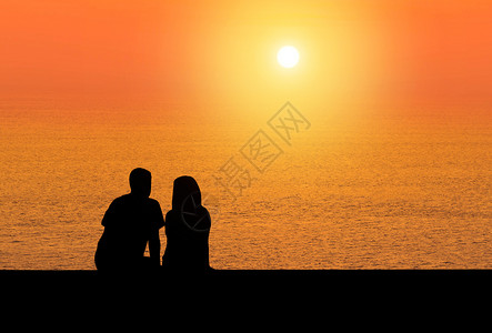 剪影后视浪漫情侣坐在沙滩图片