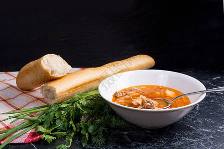 红甜菜根汤中的蔬菜和肉或白盘子里的罗宋汤图片