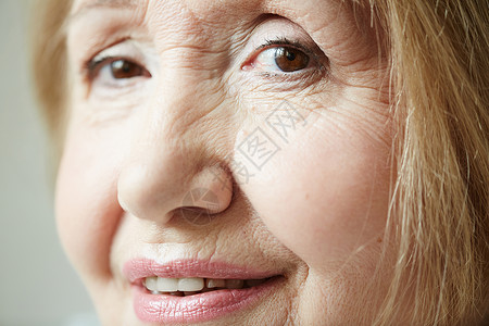 近身肖像拍摄皱纹的老年女人深棕眼睛看着镜头图片