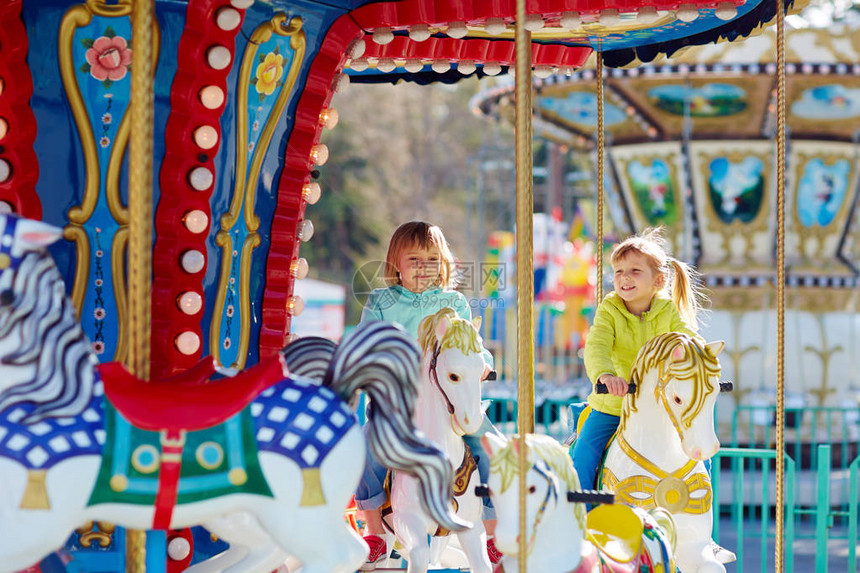 在游乐园里骑旋转木马的女孩图片