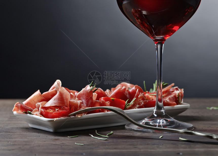 意大利熏火腿配迷迭香和一杯酒图片