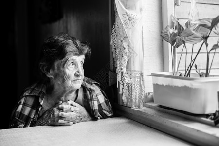 一位老妇人在窗外憔悴黑白照片图片