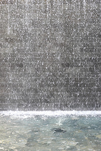 水流在池塘中的石墙用来设计背景图片