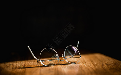 像优雅现代眼镜般的布丁办公室桌子和黑背景上薄钛子边图片