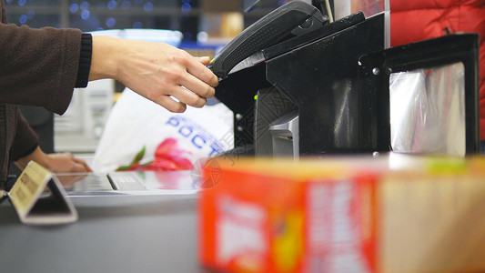 购物者在结账时为产品付款超市传送带上的食物有收银员和终端的收银台在大卖场收银员的工作在商背景图片