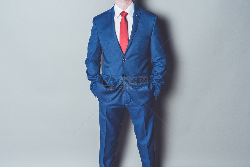 在灰色背景下穿蓝西领和红色领带的成图片