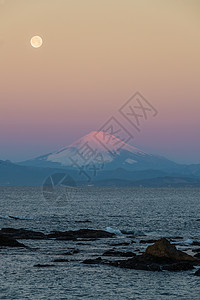 富士山和海冬季天空中的早晨满月图片