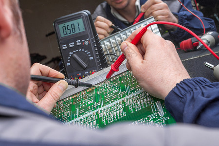 电动工程师在用多米计来检查电路板单元时图片