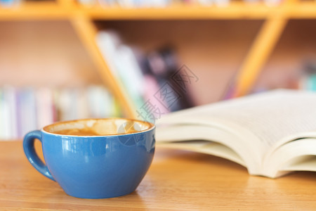 蓝咖啡杯和书放在桌上图片
