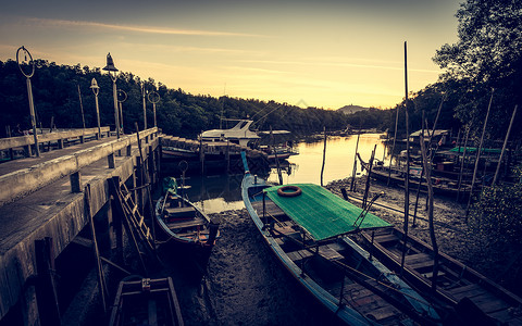 日落时低潮下码头与许多渔船图片