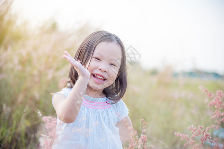 在草地上微笑的亚洲小女孩图片
