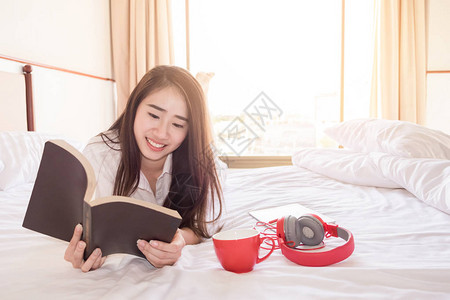 早上在床上看书和喝咖啡的女人图片