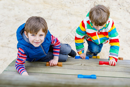 两个快乐的男孩在户外操场上玩耍和攀爬图片