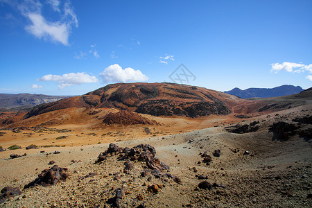 在特内里费岛徒步旅行以其独特的自然风光和对比鲜明的景观而闻名气势磅礴的泰德浓密的帕萨特云湛蓝的天空令人敬畏的植物图片