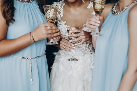 用香槟敬酒的新娘和伴娘的手图片