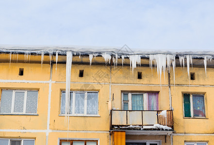 房子屋顶上的Lcicles和雪图片