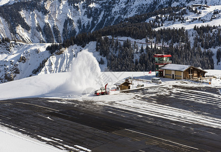 冬季高山边的吹风机扫雪者正在清理小型机场高空图片
