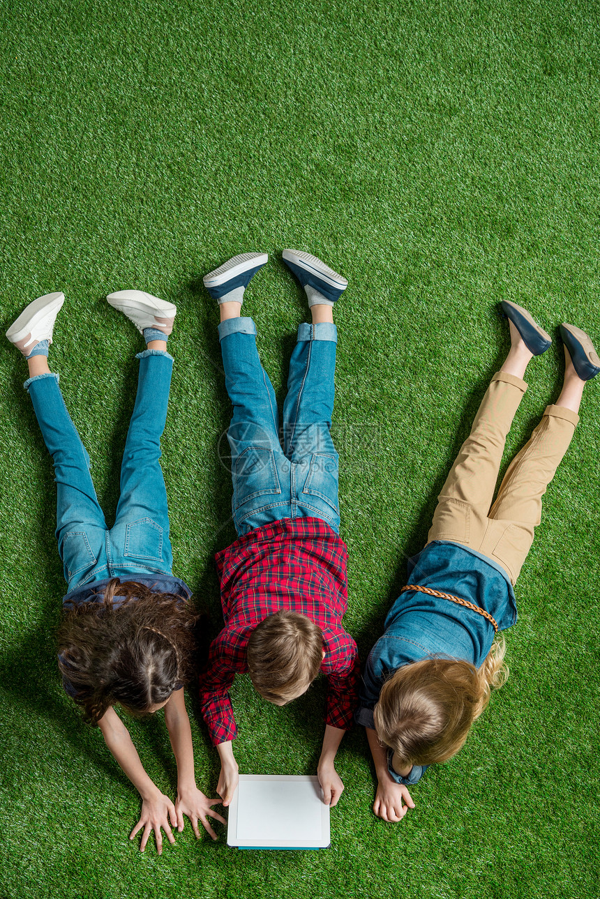儿童在躺草地上时使用图片