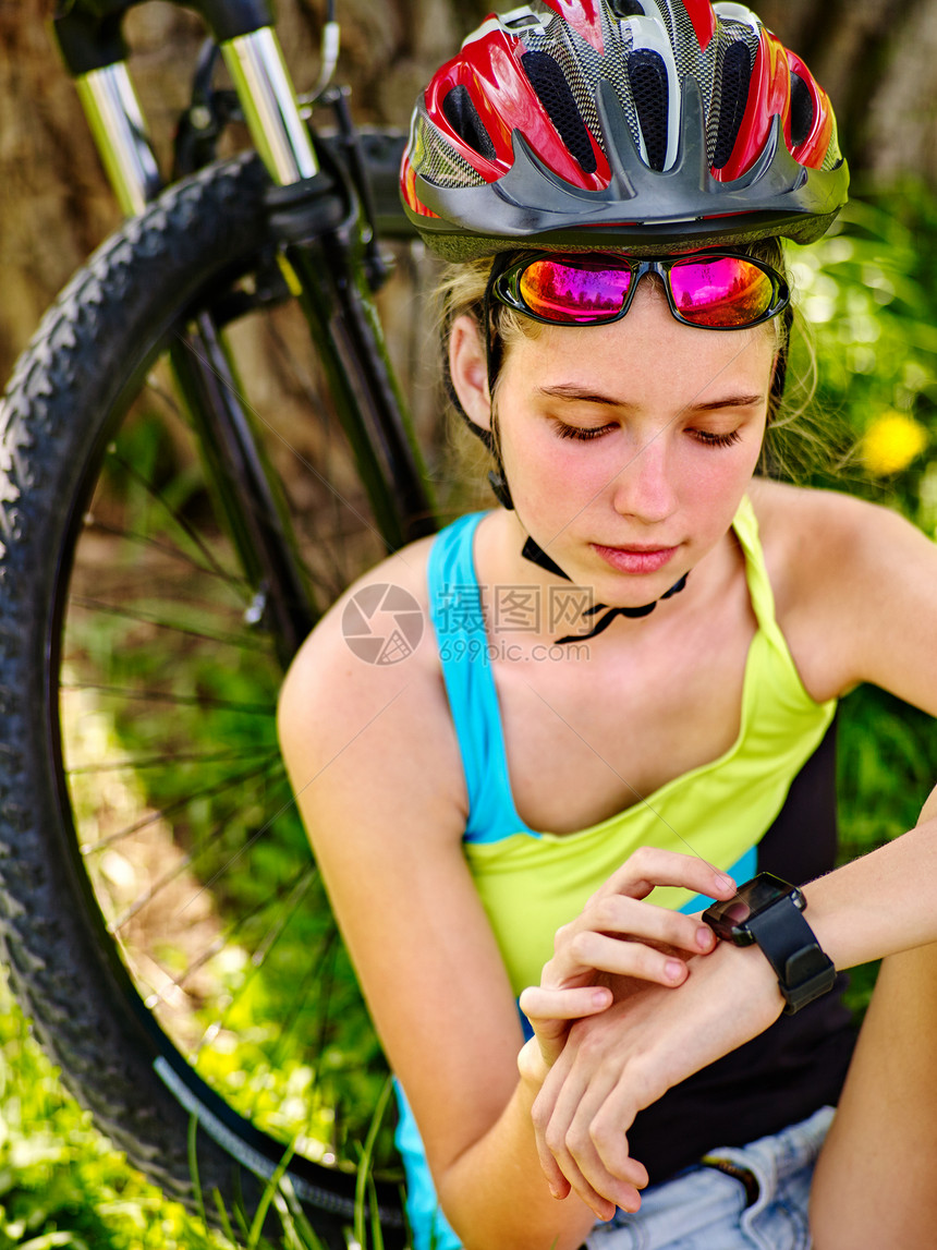 夏日公园里的儿童旅行自车骑自行车的少年女孩在智能手表上观看女孩在运动训练后数脉搏定期的自行车课图片