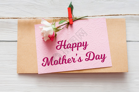 母亲日背景手工贺卡和白木上的玫瑰花图片