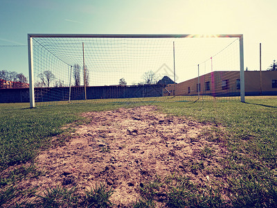 在绿草和模糊的体育场的足球网背景图片