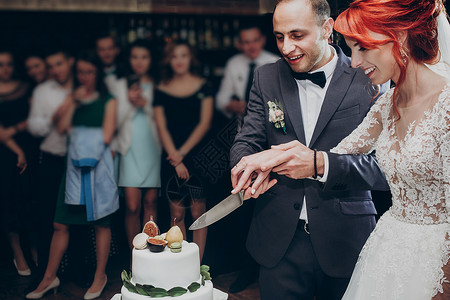 幸福的新婚夫妇一起切结婚蛋糕图片