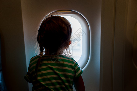 可爱的小女孩乘飞机旅行孩子坐在飞机窗图片