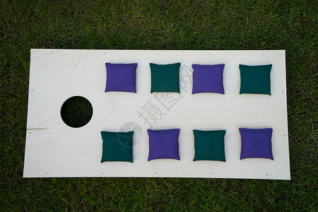 平坦的普通玉米洞板上面有绿色和紫色豆背景图片