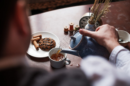 那人倒了一杯热茶甜就躺在桌上图片