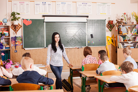 年轻女教师在小学向儿童教授图片