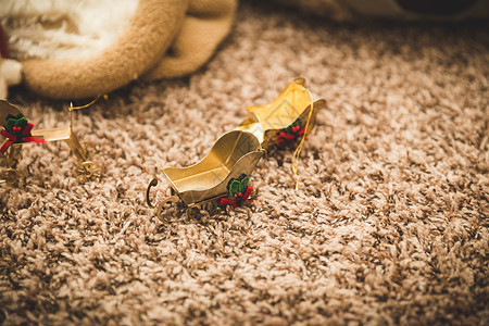 地毯上的金色圣诞雪橇饰品图片