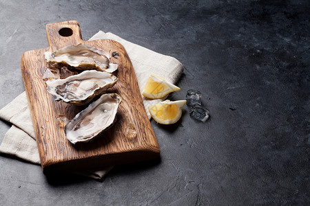 木板上露开的牡蛎冰和柠檬在石板上高清图片