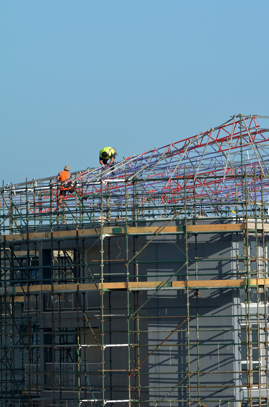 脚手架上无法辨认的建筑工人建筑建筑热潮和劳动保护概图片