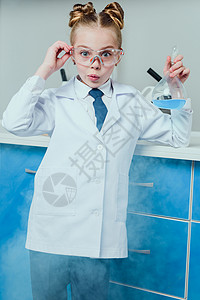 身穿保护目镜和白大衣在科学实验室用试剂盛着图片