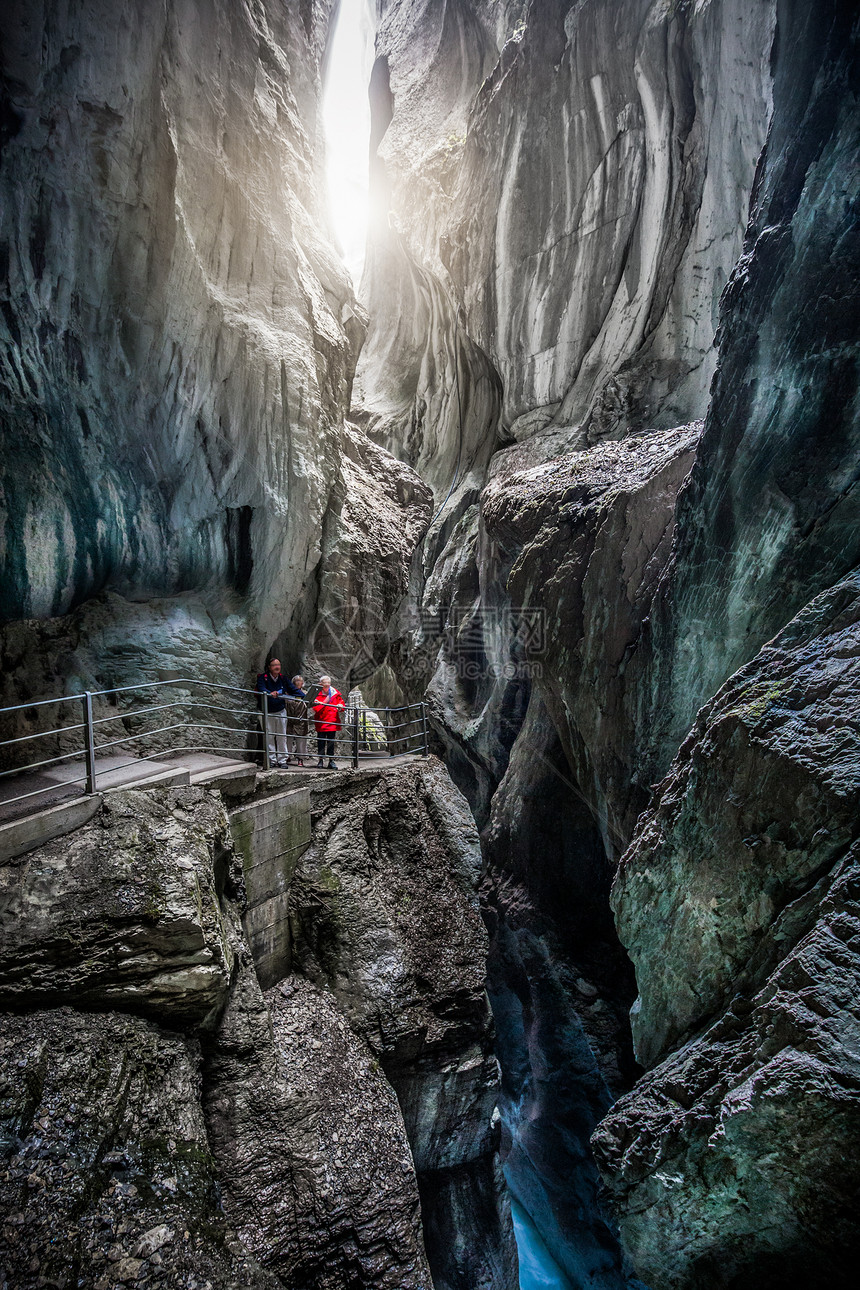 游客在瑞士伯尔尼阿尔卑斯山的夏季徒步穿越著名的神秘罗森劳伊冰川峡谷RosenlauiGletscherschlucht的美丽景色图片