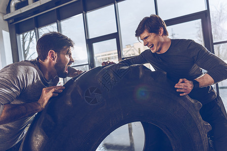 在健身房锻炼时男人拉着轮胎一图片