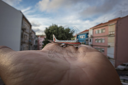 掌中俯瞰城市的微型飞机图片