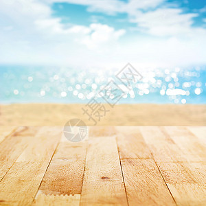 位于模糊的夏季沙滩和阳光明媚的天空背景上的木板图片