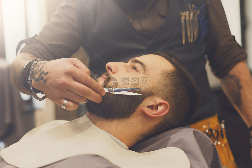 理发师在理发店用剪刀胡须客户头部特写男图片