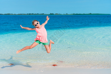 可爱的小女孩在海滩上带着海星图片