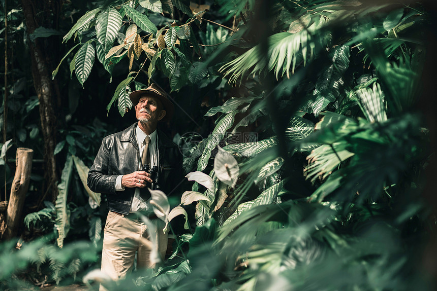 警觉的探险家站在丛林中环顾四周图片