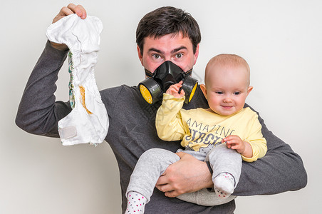 父亲戴着防毒面具拿着脏尿布和小女婴图片