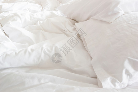 卧室里起皱凌乱的毯子和白色枕头图片