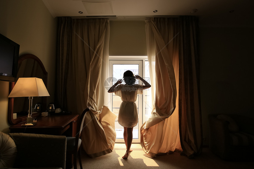 全身穿浴袍的年轻女子在旅馆房间打开卧室图片
